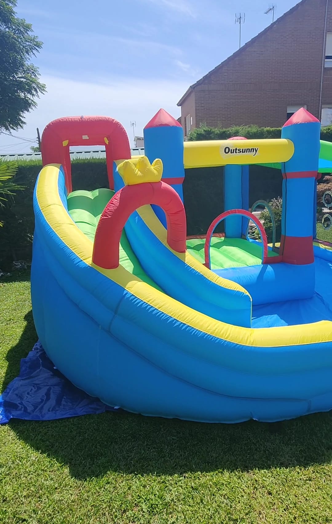 Castillo hinchable acuático con tobogán y piscina montado en un jardín